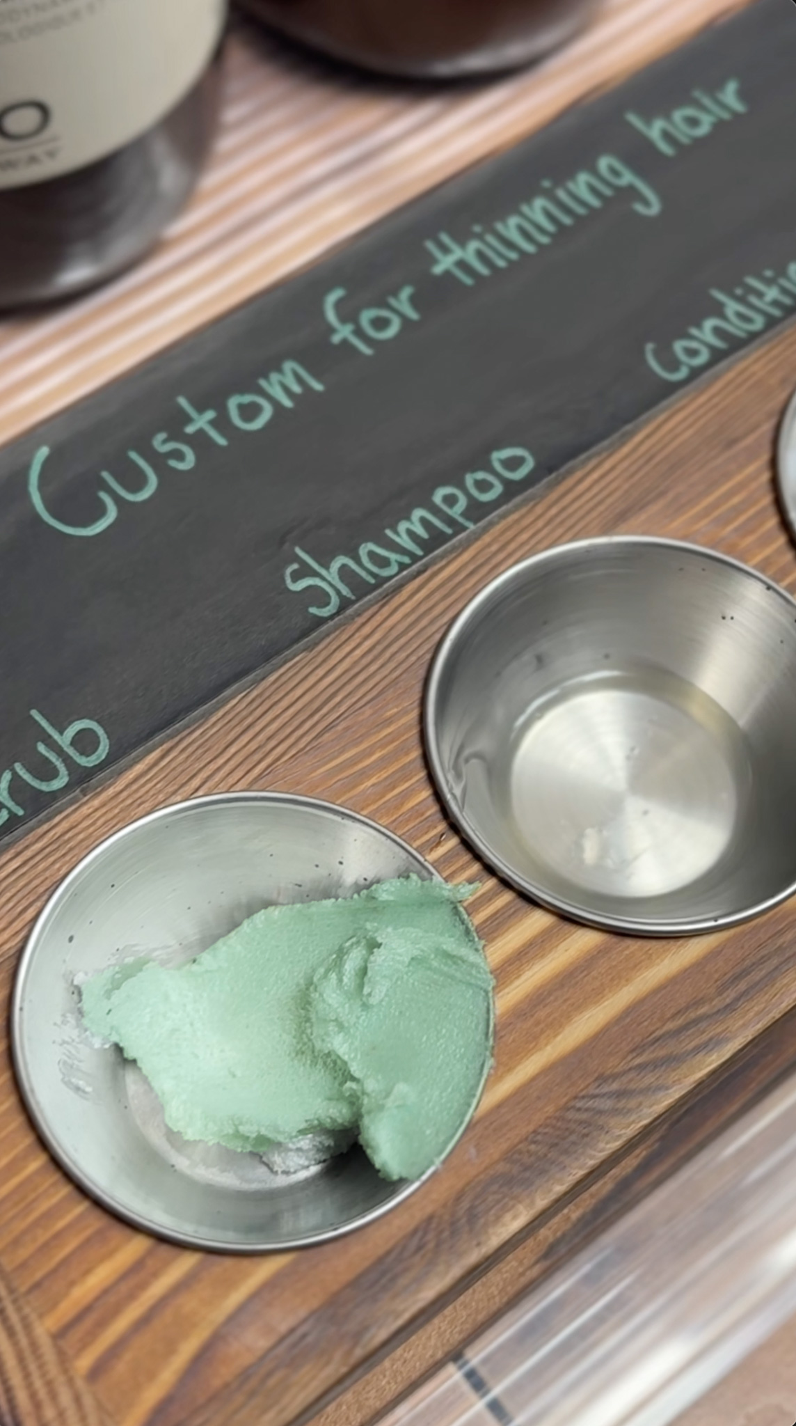 A custom board with small silver ramekin/cup filled with products that are personalized for each guest.