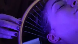 Head spa stylist using the "halo" to guide the stream of water over the scalp of a relaxed client.